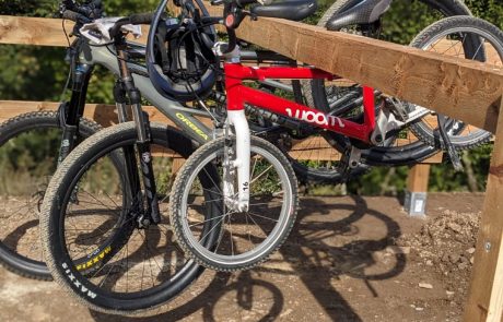 Mountainbike und Kinderrad lehnen am Holzgeländer des Pumptracks – Pumptrack Bikeparcours Bad Fredeburg