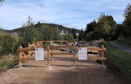 Eingang zum Pumptrack mit Holzgeländer und Hinweisschildern – Pumptrack Bikeparcours Bad Fredeburg