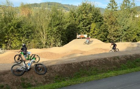 Biker auf den Wellen des Pumptracks, Bikes am Streckenrand – Pumptrack Bikeparcours Bad Fredeburg
