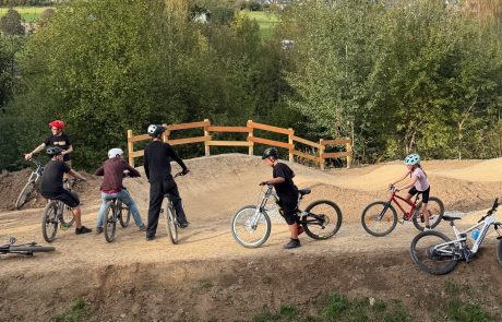 Gruppe von Kindern mit Bikes am Holzgeländer des Pumptracks – Pumptrack Bikeparcours Bad Fredeburg