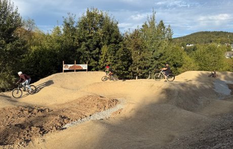 Panorama des Pumptracks mit mehreren Fahrern auf den Wellen – Pumptrack Bikeparcours Bad Fredeburg